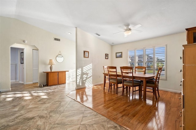 dining room with ceiling fan, lofted ceiling, and light wood-type flooring