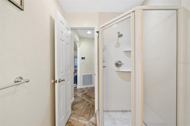 bathroom with a shower with door