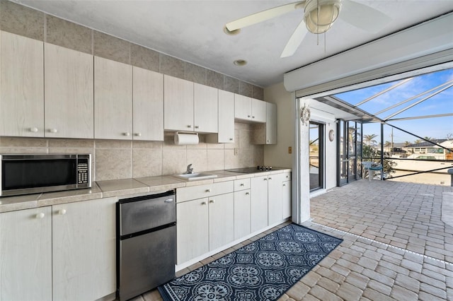 kitchen with sink, backsplash, ceiling fan, and appliances with stainless steel finishes