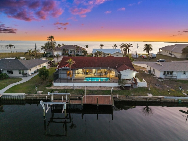 aerial view at dusk featuring a water view