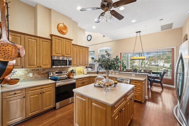 kitchen featuring stainless steel appliances, a center island, backsplash, and decorative light fixtures