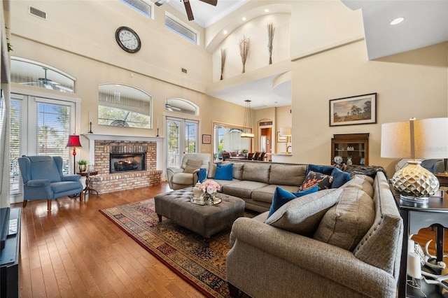 living room featuring hardwood / wood-style flooring and a brick fireplace