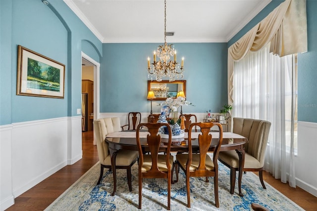 dining room featuring wood-type flooring, a notable chandelier, and crown molding