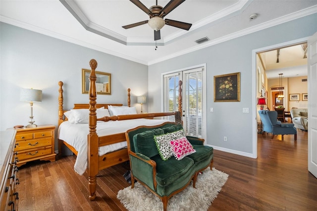 bedroom featuring dark wood-type flooring, crown molding, a raised ceiling, and access to outside