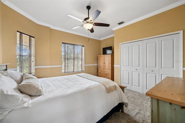 carpeted bedroom with ornamental molding, a closet, and ceiling fan