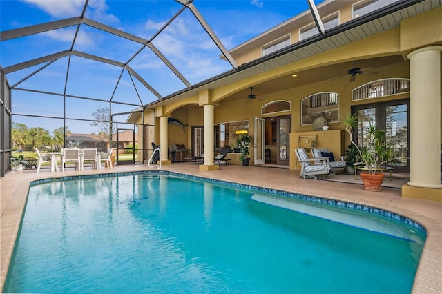 view of swimming pool with a grill, a patio area, ceiling fan, and glass enclosure