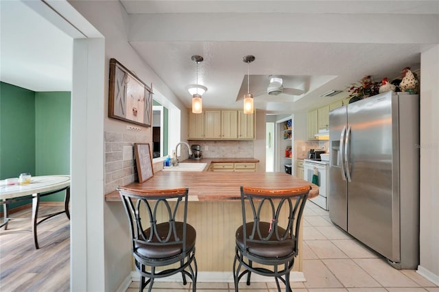 kitchen with stainless steel refrigerator with ice dispenser, white electric range, wooden counters, kitchen peninsula, and decorative backsplash