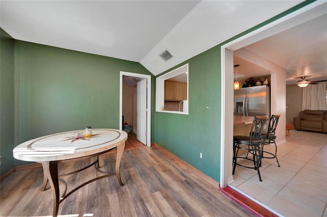 dining area featuring hardwood / wood-style floors, vaulted ceiling, and ceiling fan