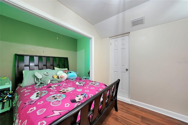 bedroom with dark wood-type flooring and vaulted ceiling