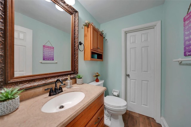 bathroom with vanity, wood-type flooring, and toilet