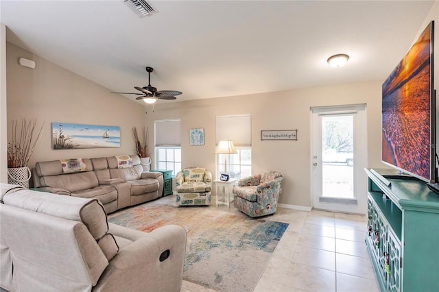 living room featuring ceiling fan, vaulted ceiling, and light tile patterned floors