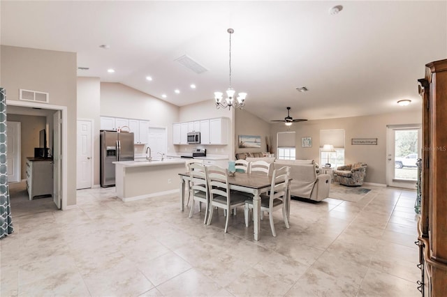 dining room featuring lofted ceiling, sink, and ceiling fan with notable chandelier