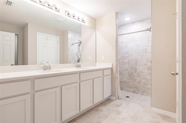 bathroom featuring a tile shower and vanity