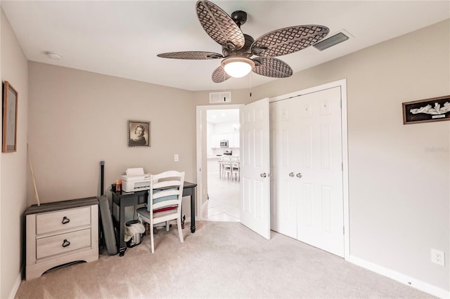 carpeted home office featuring ceiling fan