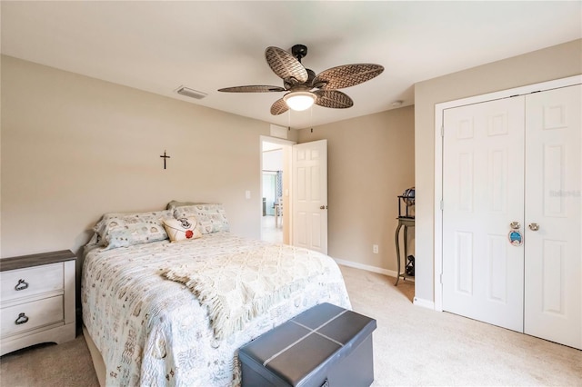 bedroom featuring light carpet, ceiling fan, and a closet