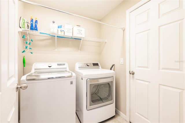 laundry area featuring washer and dryer and light tile patterned flooring