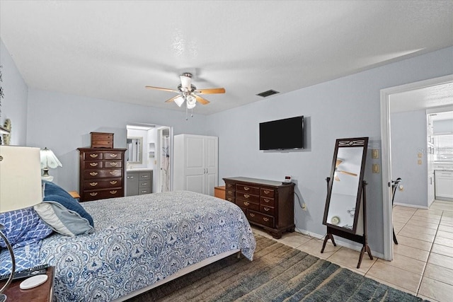 tiled bedroom with connected bathroom, a textured ceiling, and ceiling fan