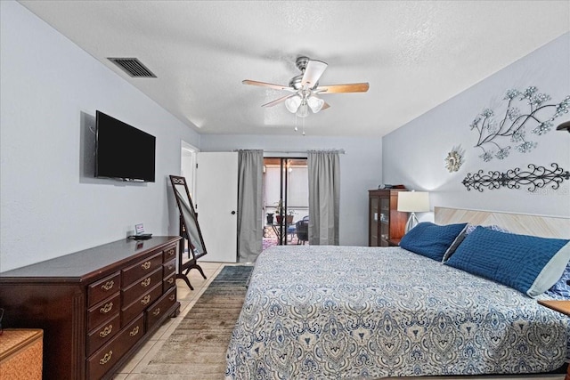 bedroom with light tile patterned flooring, ceiling fan, access to exterior, and a textured ceiling