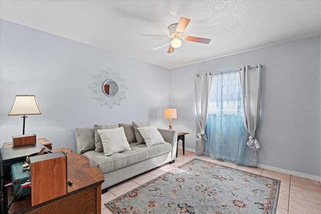 living room with light tile patterned flooring, ceiling fan, and a textured ceiling