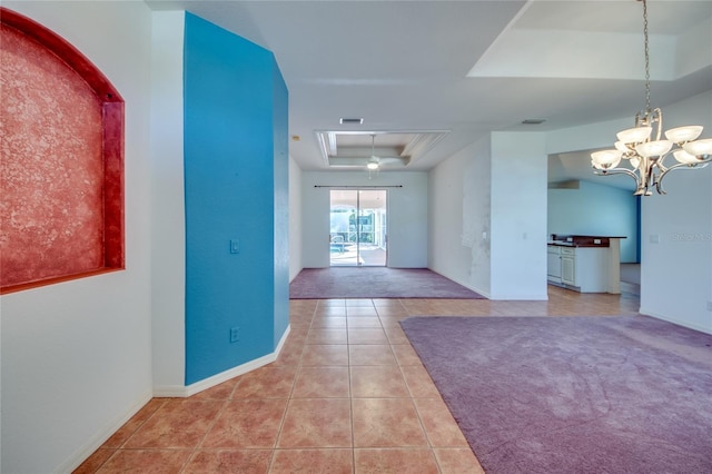 interior space with light tile patterned flooring, a tray ceiling, and a notable chandelier