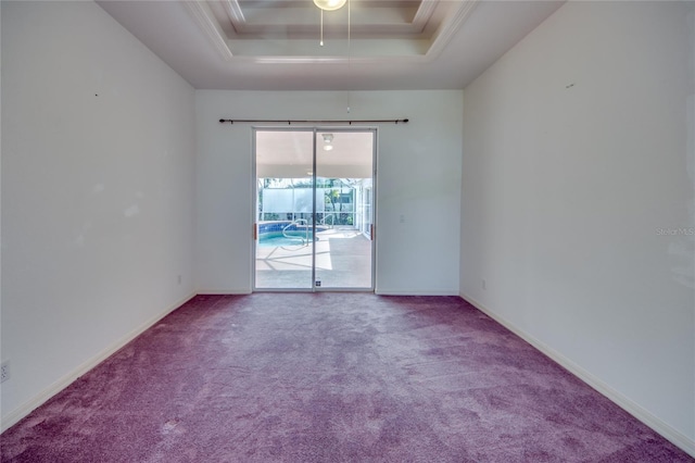 unfurnished room featuring a tray ceiling, carpet floors, and ornamental molding