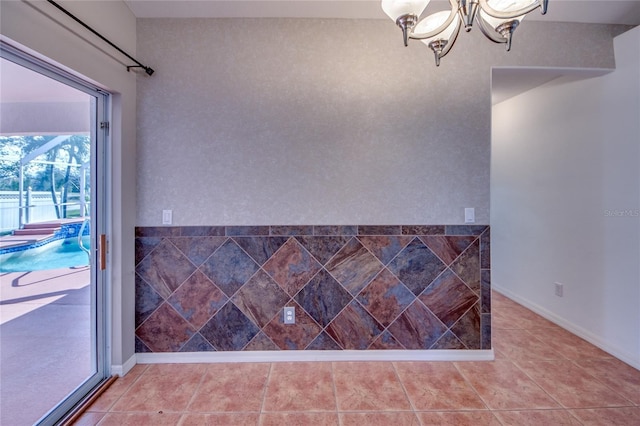 tiled empty room with a notable chandelier