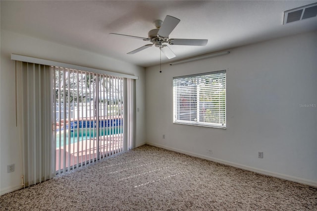 carpeted spare room with ceiling fan