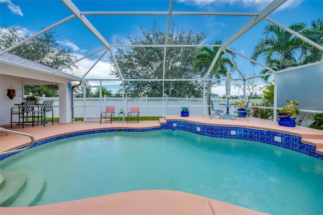 view of swimming pool featuring a patio and glass enclosure