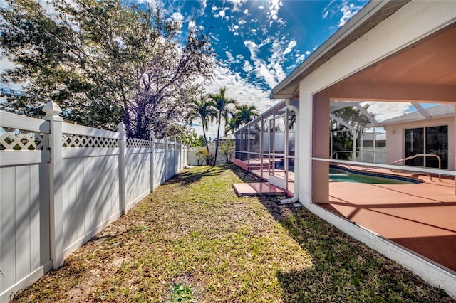 view of yard with a fenced in pool, a patio, and glass enclosure