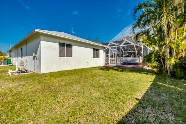 back of house with a lanai, central air condition unit, and a lawn