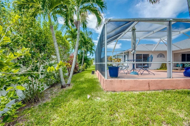 view of yard with a patio and glass enclosure