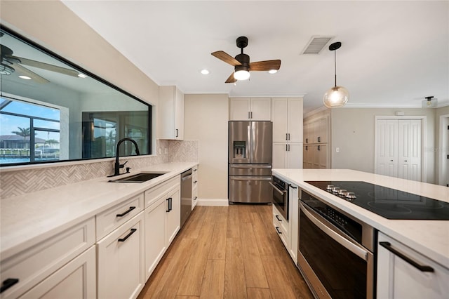 kitchen featuring white cabinetry, sink, backsplash, and appliances with stainless steel finishes