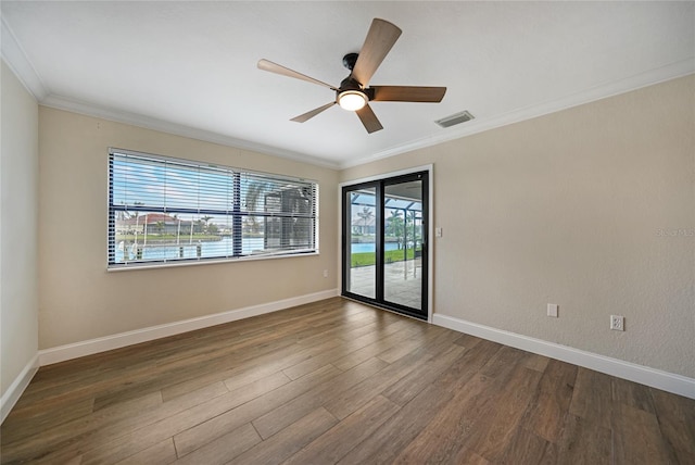 empty room featuring dark wood-type flooring, ornamental molding, and ceiling fan