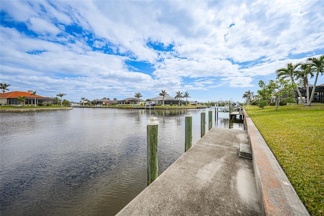 view of dock featuring a water view and a yard