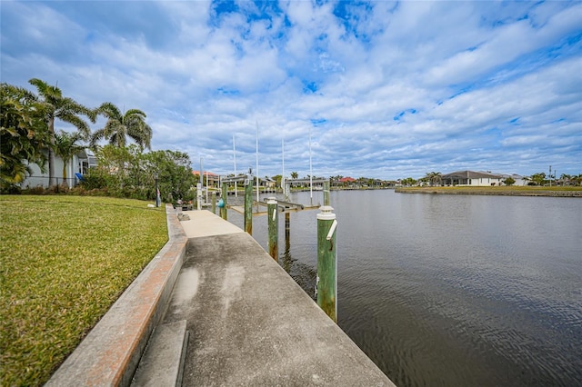 dock area with a lawn and a water view