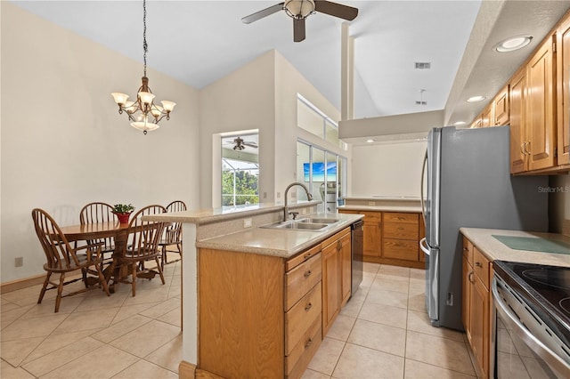 kitchen featuring dishwasher, sink, hanging light fixtures, a kitchen island with sink, and light tile patterned floors