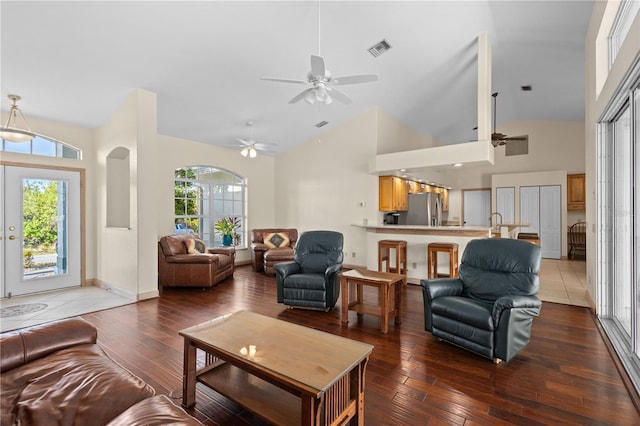 living room with wood-type flooring, high vaulted ceiling, and ceiling fan