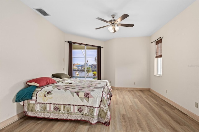 bedroom with multiple windows, ceiling fan, and light hardwood / wood-style flooring