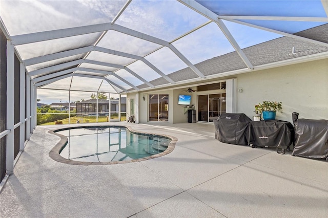 view of swimming pool featuring ceiling fan, a lanai, and a patio