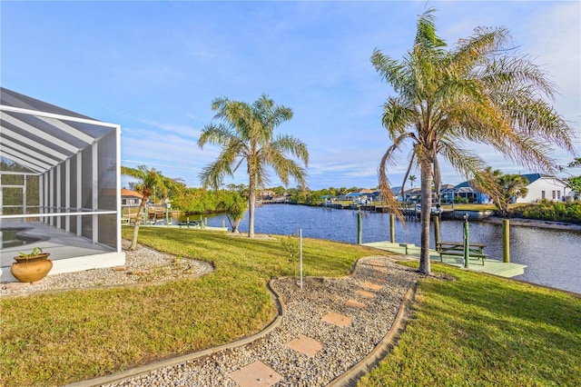 view of yard with a water view and glass enclosure