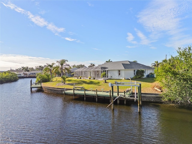 view of dock featuring a water view, glass enclosure, and a lawn