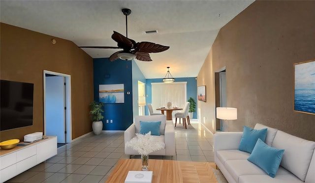 tiled living room with ceiling fan and high vaulted ceiling