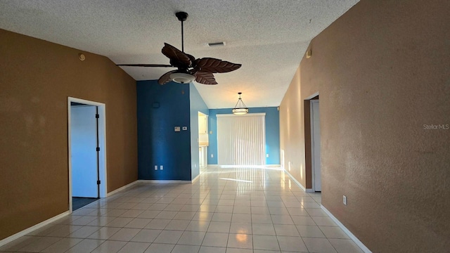 spare room with ceiling fan, high vaulted ceiling, a textured ceiling, and light tile patterned floors