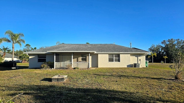 rear view of property with a yard, a sunroom, and central air condition unit