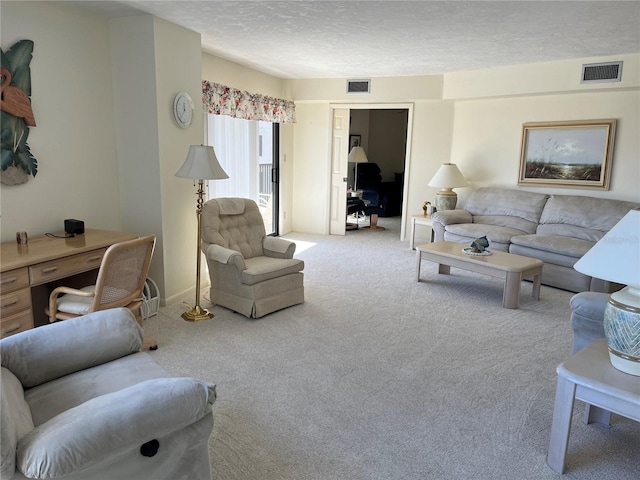 living room with carpet floors, visible vents, and a textured ceiling