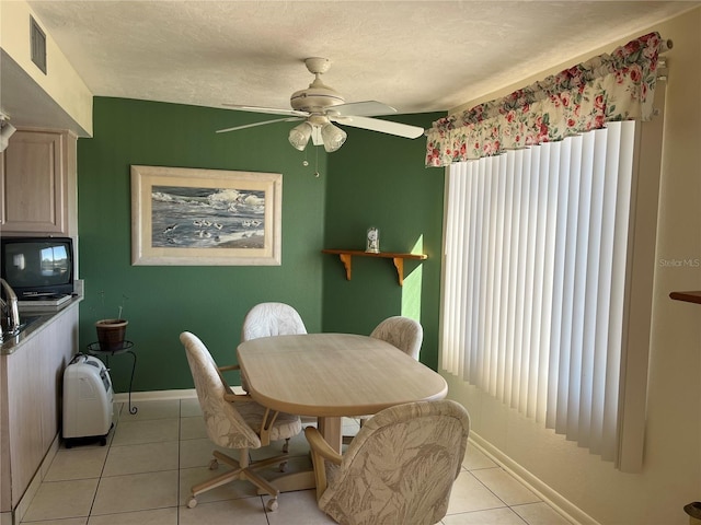 dining space featuring light tile patterned floors, baseboards, visible vents, ceiling fan, and a textured ceiling