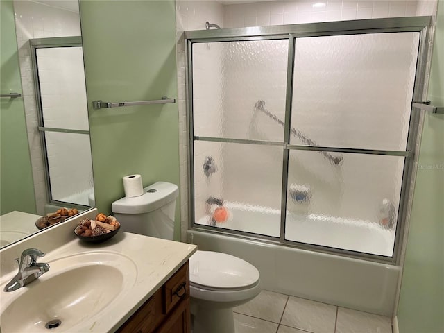 bathroom featuring toilet, shower / bath combination with glass door, tile patterned floors, and vanity