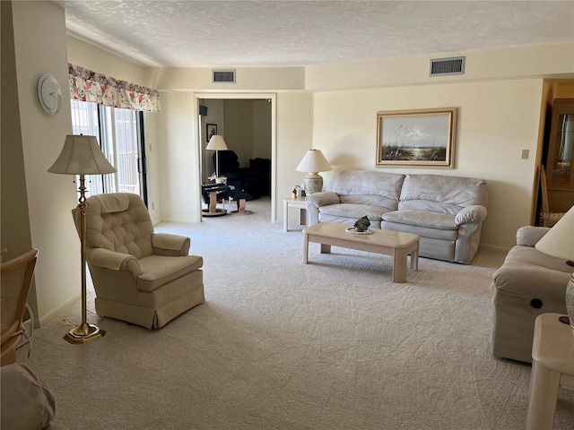 living room with baseboards, carpet, visible vents, and a textured ceiling