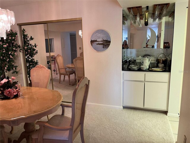 dining space with light carpet and baseboards