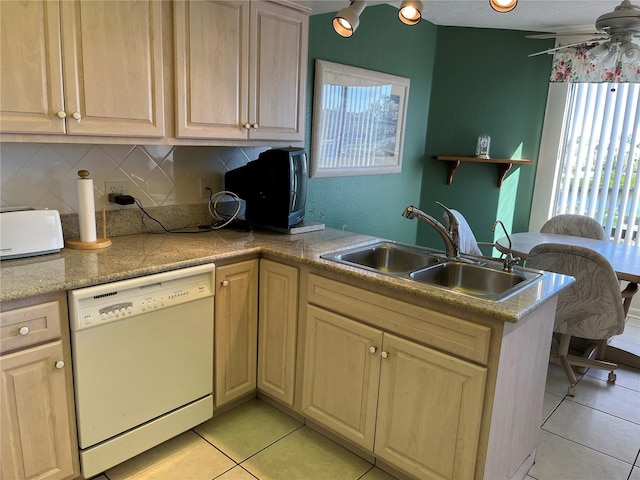 kitchen featuring dishwasher, backsplash, a sink, and light tile patterned floors